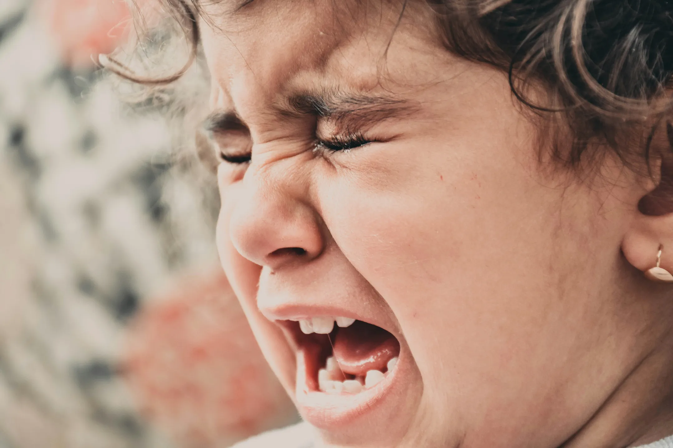 A young child mid-tantrum, crying